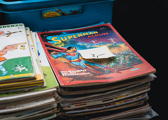 Stack of vintage comic books with a Superman album on top, illustrating interesting scientific facts with an eerie theme.