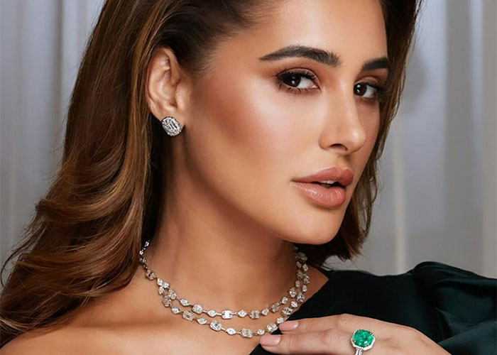 Young woman wearing elegant jewelry, showcasing a diamond necklace and emerald ring, illustrating interesting scientific facts.