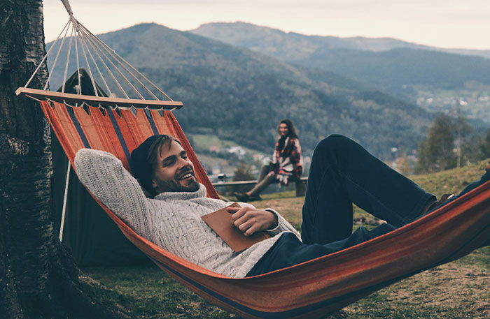 Man relaxing in a hammock outdoors, illustrating employee frustration about promised raises not being rolled out.