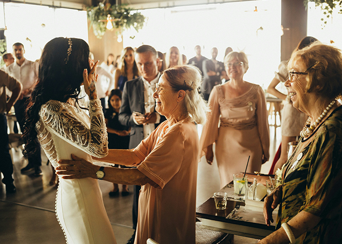 Woman in a wedding dress interacts with guests at a wedding, highlighting the bride and SIL family moment.