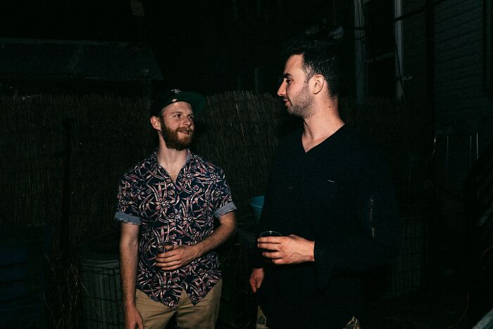 Two men talking outside at night, representing a casual scene linked to school bullies and their life outcomes.