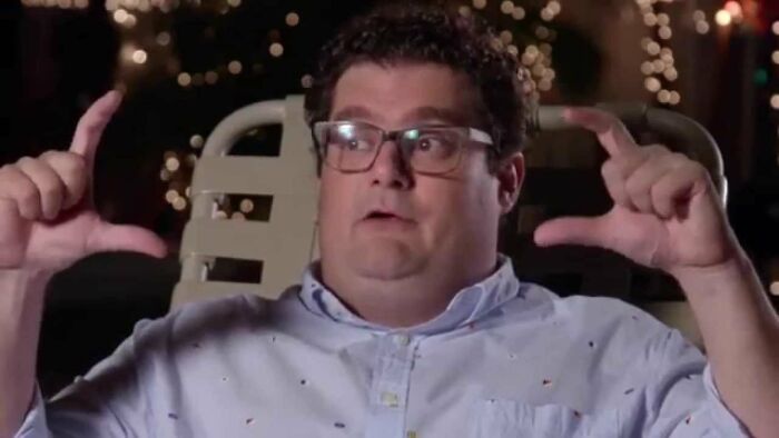 Man with glasses gesturing with hands while sharing a story about running into celebrities and worst experiences at night.