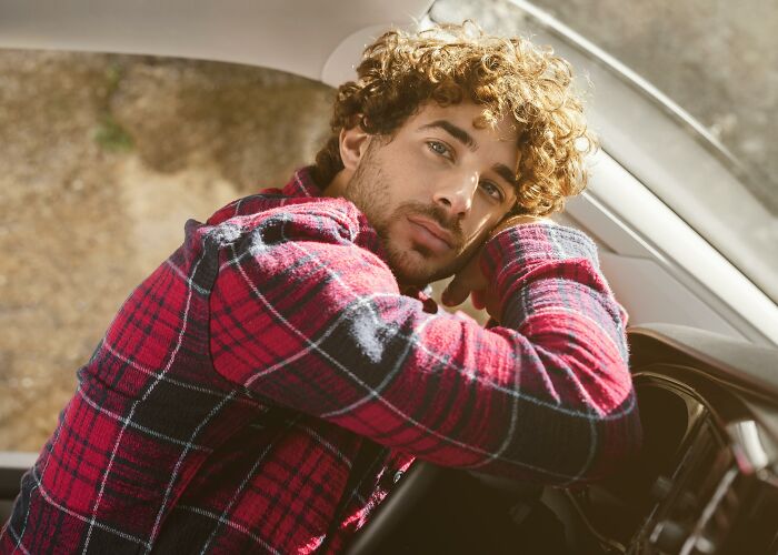 Young man looking worried while sitting inside a car, reflecting people who saw scary creepy situations moments.