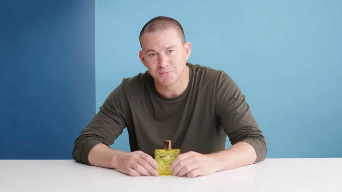 Man sitting at table holding yellow bottle, smiling warmly, illustrating heartwarming celebrity encounters shared by netizens.