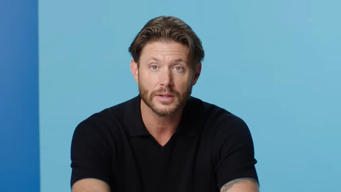 Man with beard and brown hair in a black shirt sharing a heartwarming celebrity encounter on a blue background.