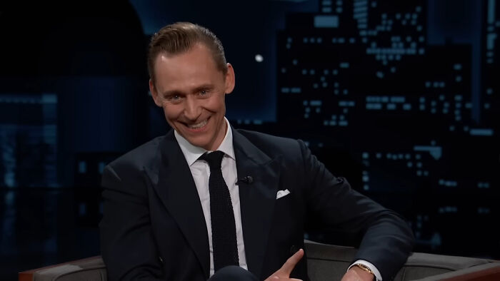 Actor in a suit sharing a heartwarming celebrity encounter on a late-night talk show, making netizens smile today.