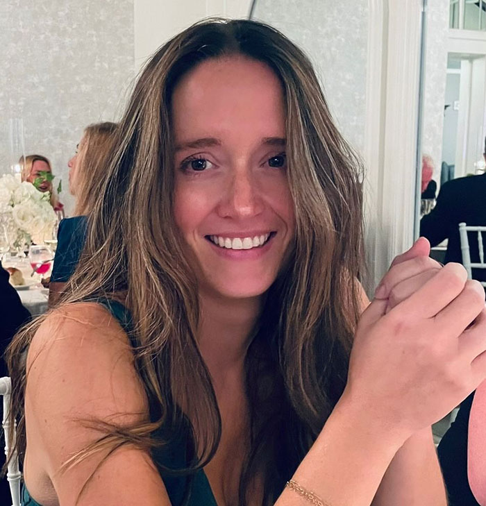 Woman who tanked boyfriend’s career over Charlie Kirk comments smiling indoors at social event with long brown hair. Woman who tanked boyfriend’s career over Charlie Kirk comments smiling indoors at social event with long brown hair.