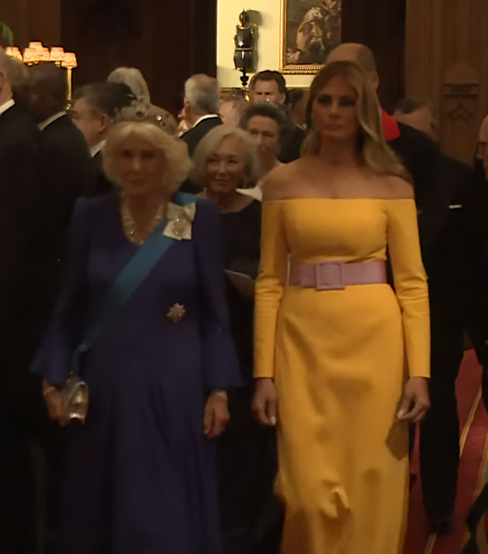Melania Trump in a yellow off-shoulder dress and pink belt, attending a formal event in the UK, outfit widely criticized. Melania Trump in a yellow off-shoulder dress and pink belt, attending a formal event in the UK, outfit widely criticized.