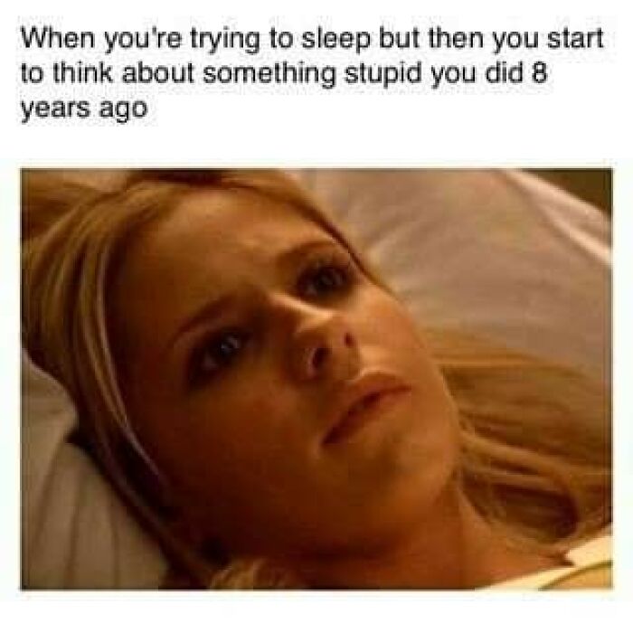 Woman lying awake in bed, staring blankly, illustrating a funny and weirdly comforting mental health meme about overthinking past mistakes.