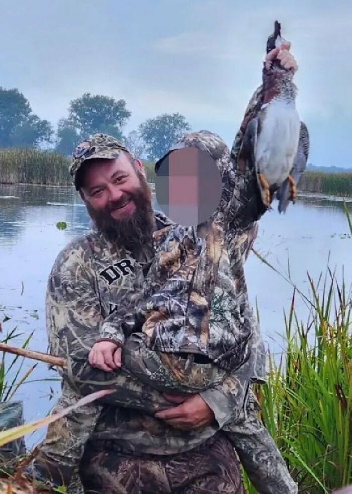 Man and child in camo holding a duck by a lake, linked to Michigan suspect's eerie confession before church attack.