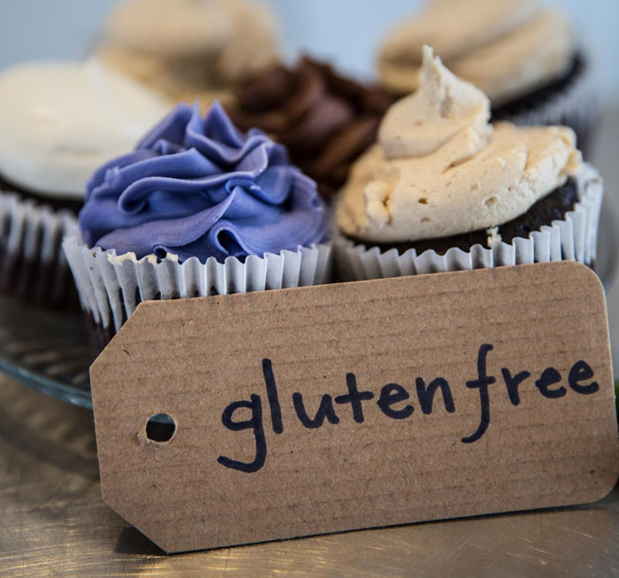 Cupcakes with gluten free label highlighting allergy-safe food at a baby shower amid sabotage concerns Cupcakes with gluten free label highlighting allergy-safe food at a baby shower amid sabotage concerns