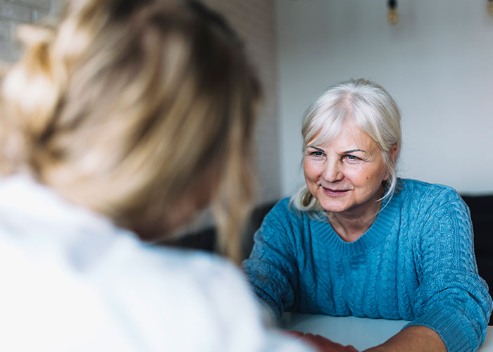 Older woman in blue sweater confronting a younger woman, illustrating tension related to purposely triggering allergies. Older woman in blue sweater confronting a younger woman, illustrating tension related to purposely triggering allergies.