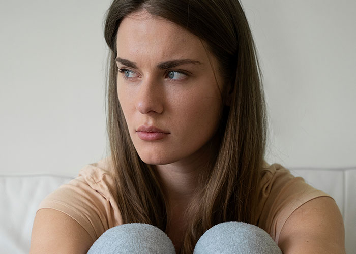 Young woman looking upset and distant, highlighting conflict with mother-in-law over purposely triggered allergies. Young woman looking upset and distant, highlighting conflict with mother-in-law over purposely triggered allergies.