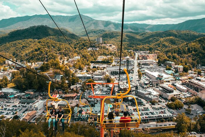 Aerial view from chairlift over a mountain town, showing unexpected scenes from popular travel destinations in person.