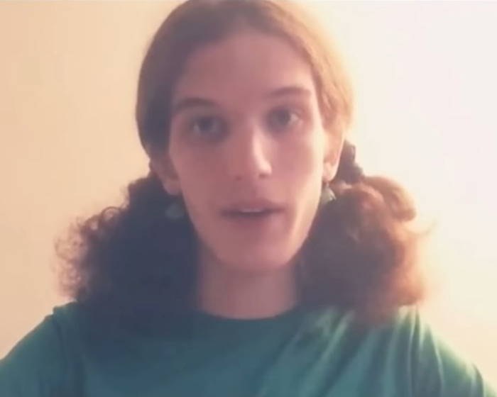 Young woman with curly hair in a green shirt, linked to Minneapolis suspect's furry girlfriend and disturbing journal entries.