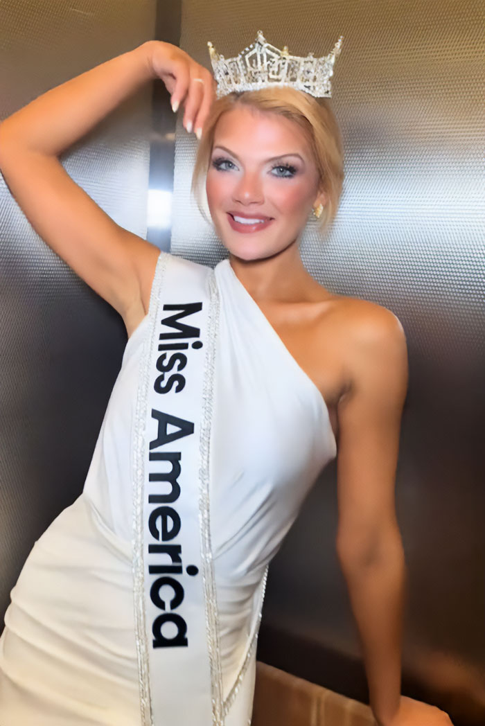 Miss America wearing a crown and sash, smiling confidently after winning amid backlash over her look.