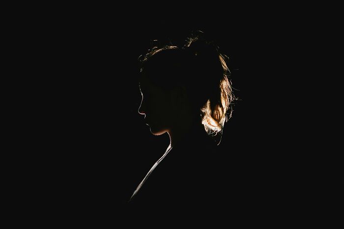 Silhouetted woman with backlit hair, representing unexplained mysteries from the dawn of the internet puzzling people today.