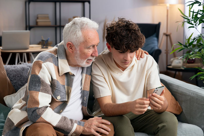 Elderly man tries to recruit young man to help care for disabled family member, young man looking reluctant on phone. Elderly man tries to recruit young man to help care for disabled family member, young man looking reluctant on phone.