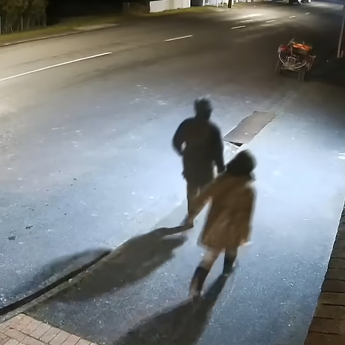 Two shadowed figures walking on a dimly lit street, related to mom of 3 missing kids and DUI court appearance.