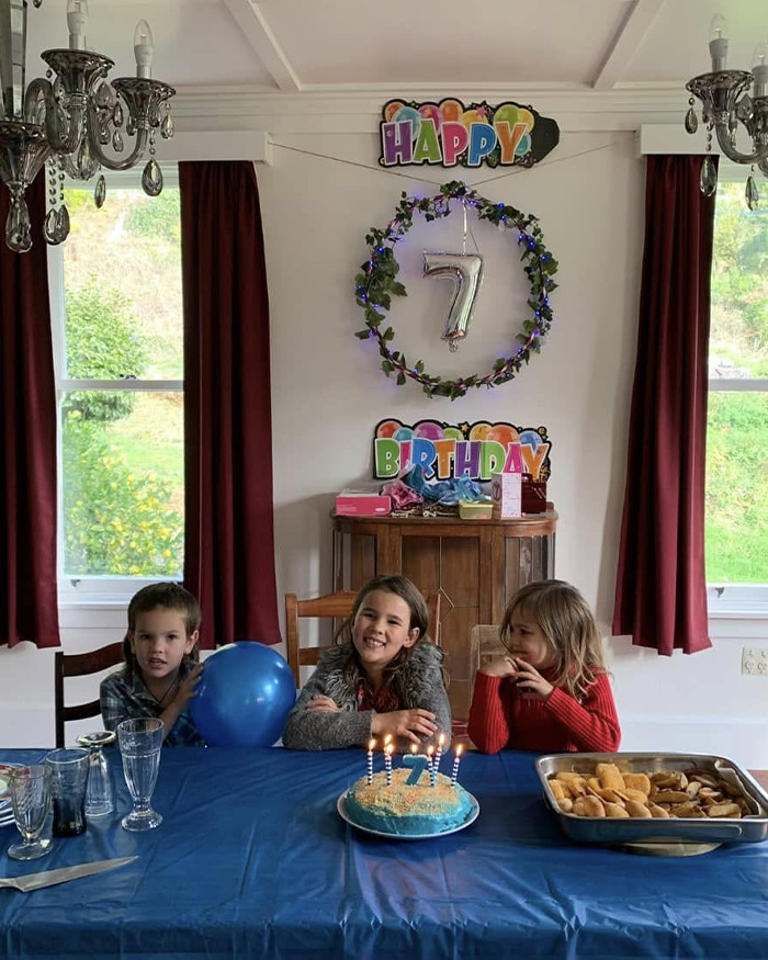 Three children celebrating a 7th birthday with cake and balloons, related to mom of 3 missing kids in court over DUI.