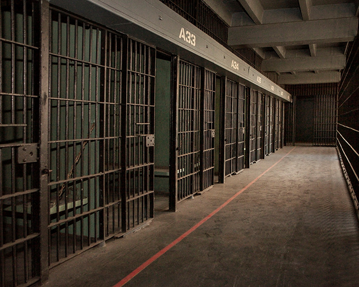 Prison corridor with multiple cell doors, illustrating the environment related to a student jailed for life in Dubai. Prison corridor with multiple cell doors, illustrating the environment related to a student jailed for life in Dubai.