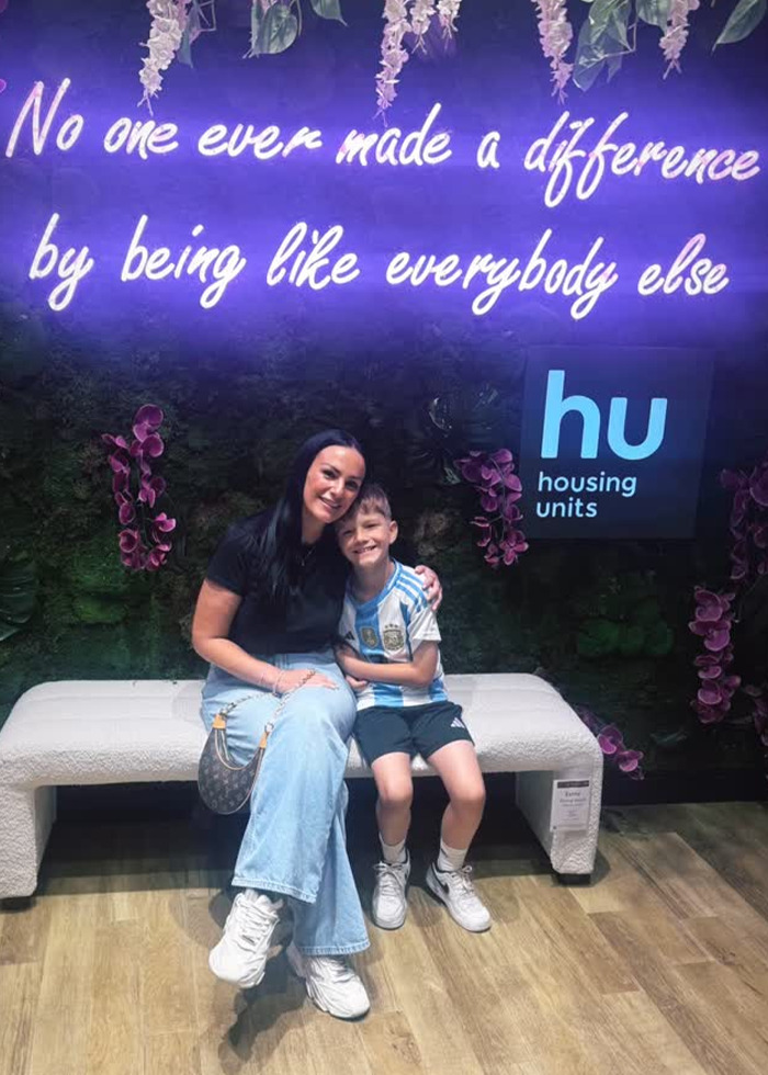 Mom and son sitting on bench smiling, illustrating a furious mom pulls son out of school after snack ban story.