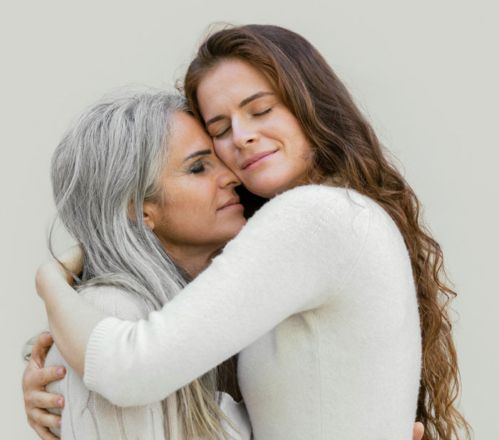 Woman and mother embracing with eyes closed, sharing an emotional moment about study abroad truth and feelings. Woman and mother embracing with eyes closed, sharing an emotional moment about study abroad truth and feelings.
