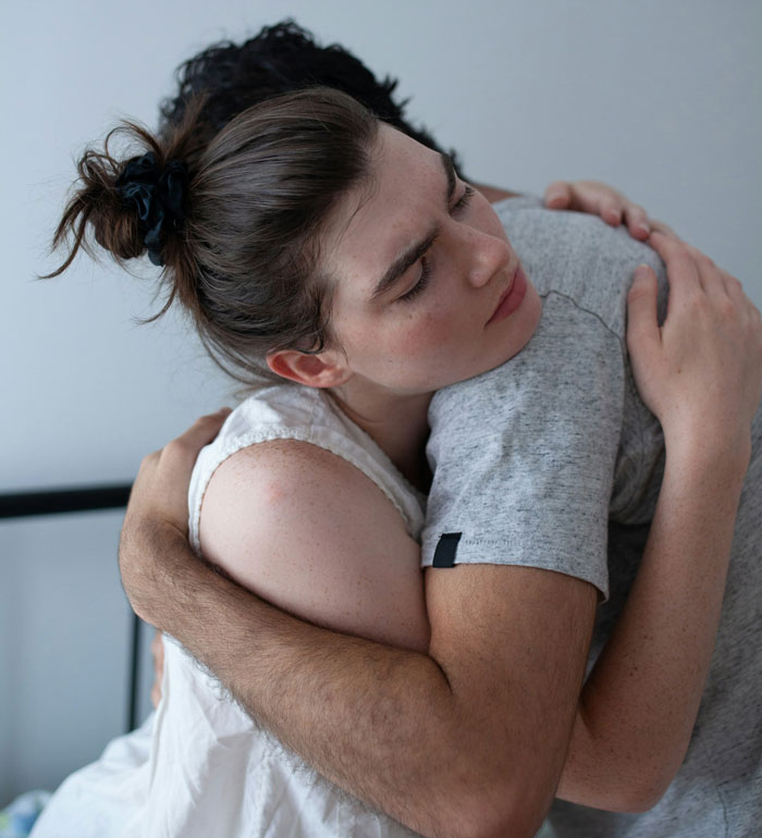 Woman with hair tied hugging a man closely, expressing emotion about why she never got to study abroad. Woman with hair tied hugging a man closely, expressing emotion about why she never got to study abroad.