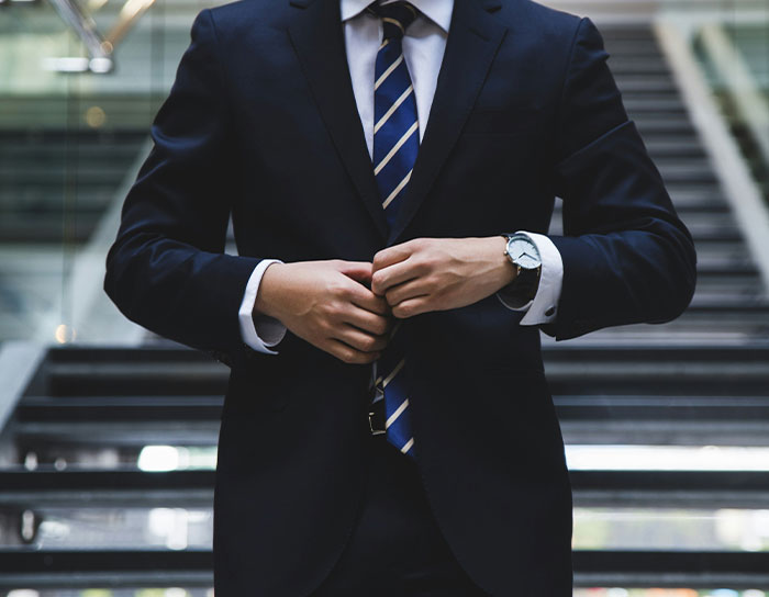 Man in a dark suit adjusting his jacket, symbolizing professions discussed in TikTok Moms career debates.