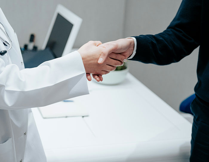 Two people shaking hands in an office setting, illustrating professions and TikTok moms discussions.