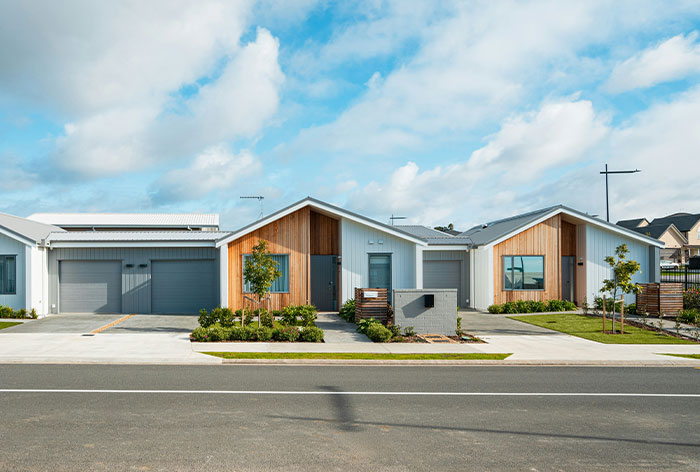 Modern suburban homes with garages under a partly cloudy sky, related to TikTok Moms and professions discussion.