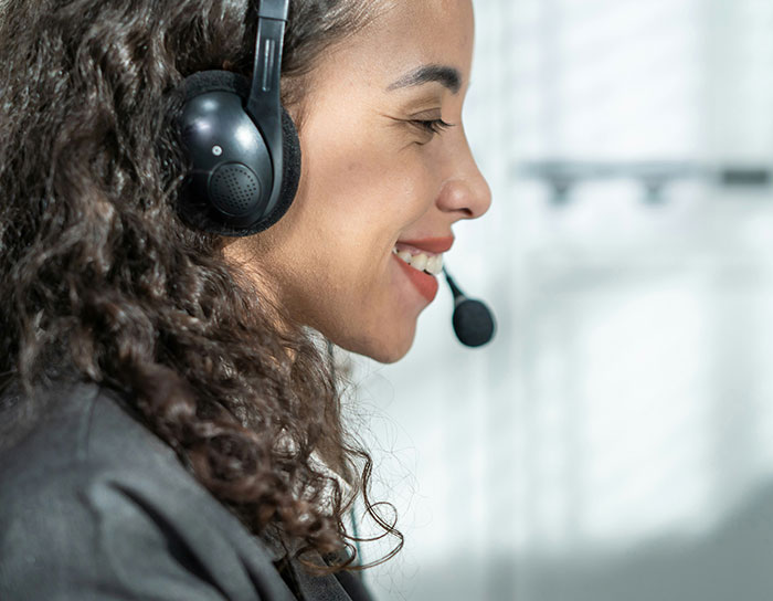 Woman wearing a headset smiling while working, illustrating common professions TikTok moms call out as disliked.
