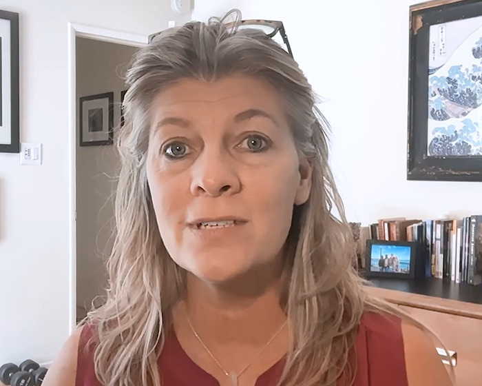 Woman making a shocking confession about anonymously bullying her daughter for a year in a home office setting.