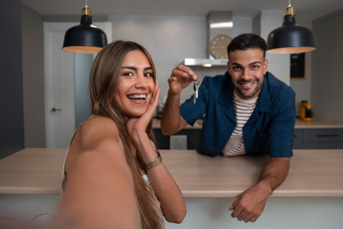 Young siblings in kitchen sharing house keys during a tense moment in a family dispute over living arrangements.