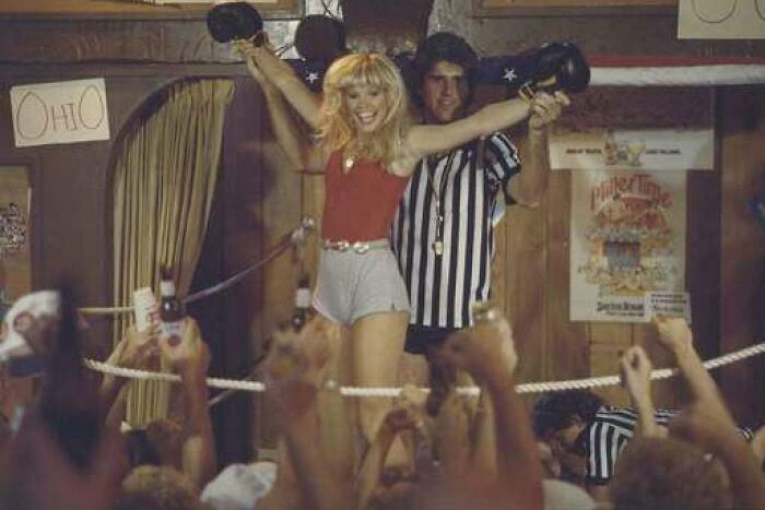 Female boxer celebrating victory in ring while referee raises her arm, linked to celebrities who vanished without a trace theories.