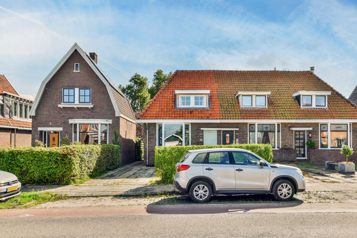 Silver SUV parked in front of a house with neighbor upset over nanny parking in front of home.