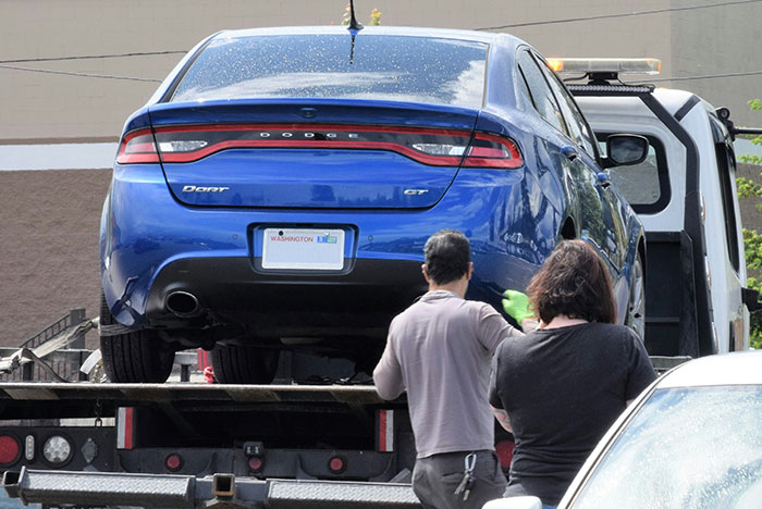 Blue Dodge Dart being towed as nurse confronts neighbor for repeatedly using her driveway after long shift.