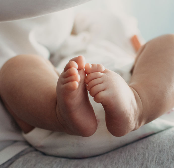 Close-up of newborn feet lying on a soft surface, illustrating tragic cheerleader arrested case involving a hidden baby.