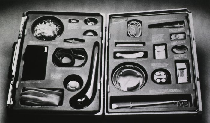 Old-school medical kit displayed in an open case showing vintage surgical instruments from the past.