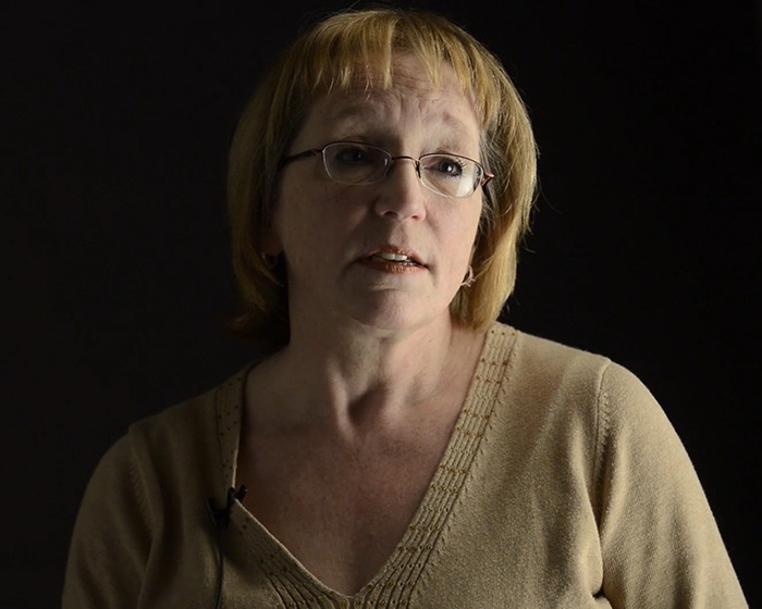 Woman with glasses speaking in a podcast setting about a teen who chewed through ropes to escape a homicide spree.