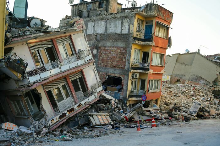 Collapsed residential buildings after an earthquake, showcasing real life scenes more bizarre than fiction in disaster aftermath.