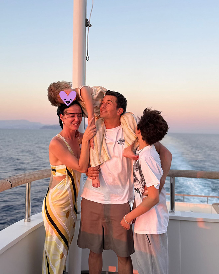 Miranda Kerr with family on a boat at sunset, reflecting on Orlando Bloom's breakup with Katy Perry.