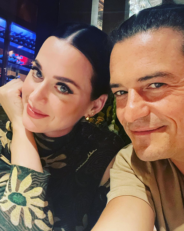 Miranda Kerr smiling in a patterned top beside a man indoors, related to Orlando Bloom breakup with Katy Perry news.