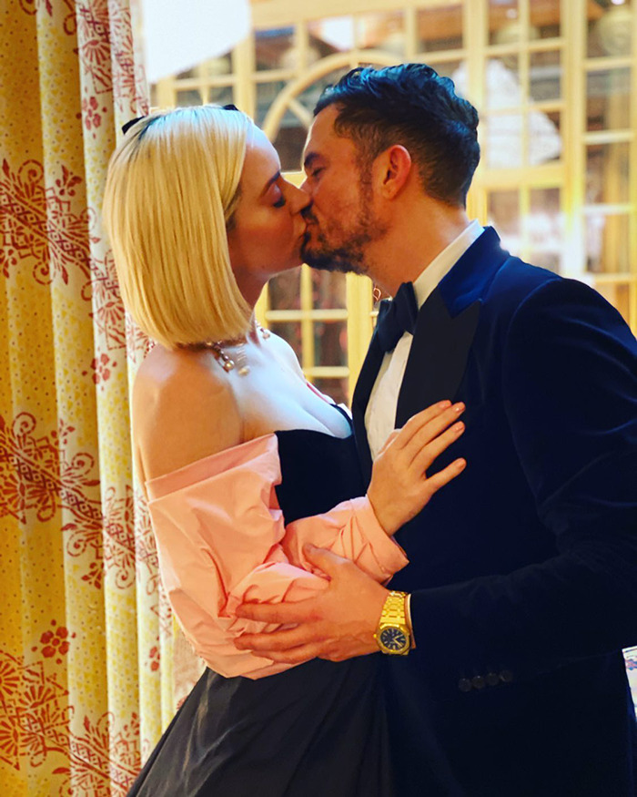 Miranda Kerr and Orlando Bloom sharing a kiss indoors, highlighting moments after Katy Perry breakup news.