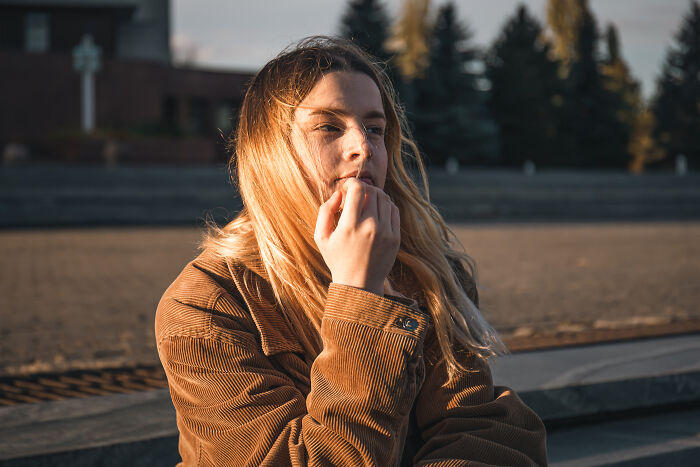 Young woman outdoors looking pensive, illustrating red flags women detect using tests on their dates.
