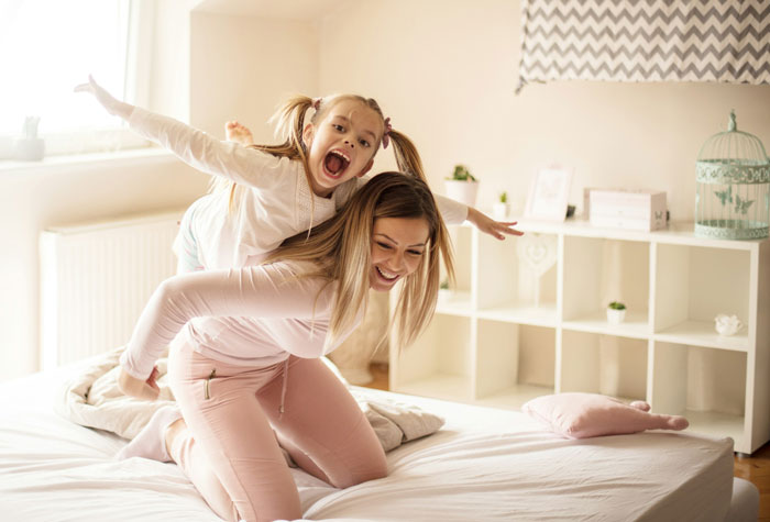 19YO forced to be a parent to little sister, showing frustration while caring and playing with her sibling at home.
