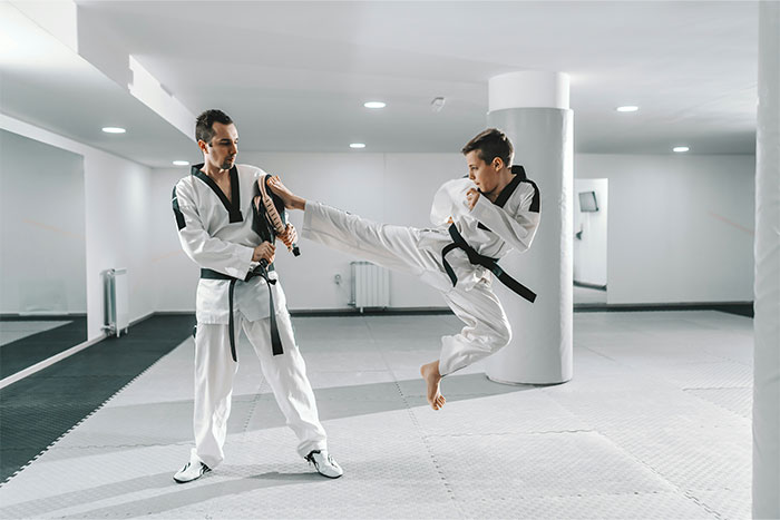 Young martial artist practicing a high kick during training, symbolizing the moment they finally got even with a bully.