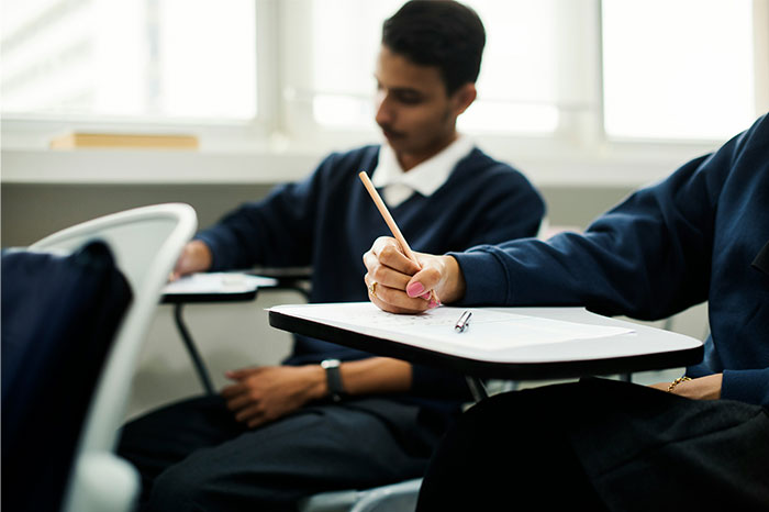 Students taking notes in a classroom, symbolizing moments of growth and overcoming challenges with bullies.