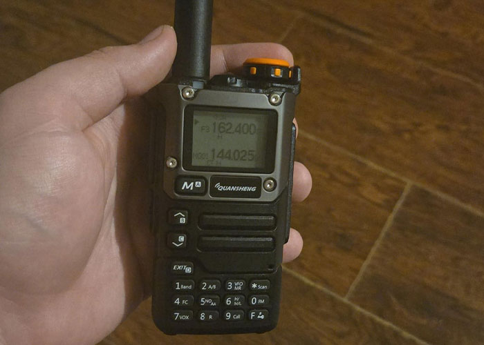 Hand holding a Quansheng walkie talkie showing frequency settings, illustrating useful life hacks that actually work.