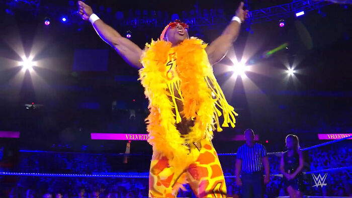 Wrestler in bright yellow and orange costume raising arms in a wrestling ring, symbolizing people who ruined their lives fast.